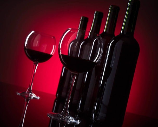 Glazen en flessen rode wijn, kopie ruimte voor uw tekst. - Foto, afbeelding