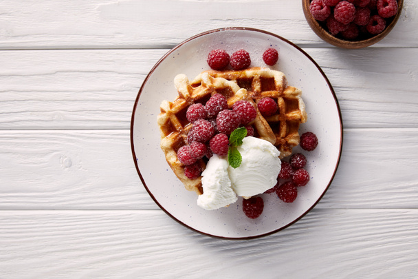 tasty belgian waffles with raspberries and ice cream on white wooden table - Fotografie, Obrázek
