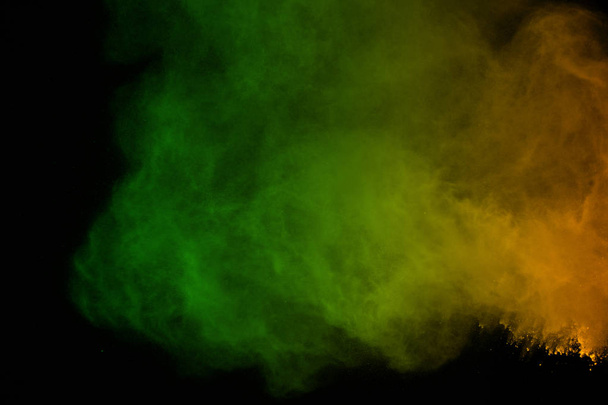 Colorful of powder explosion on black background.Freeze motion of colorful dust explosion on black background. Paint Holi.Colorful cloud splash. - Foto, afbeelding
