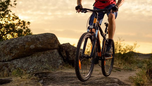 Cyclist in Red Riding the Bike on the Rocky Trail at Sunset. Extreme Sport and Enduro Biking Concept. - Photo, Image