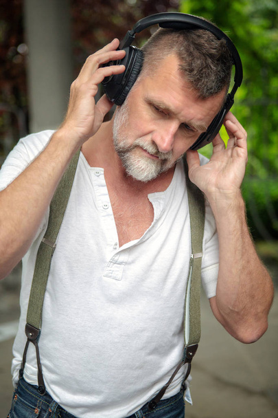portrait of handsome bearded man in his 50s with headphones  - Φωτογραφία, εικόνα