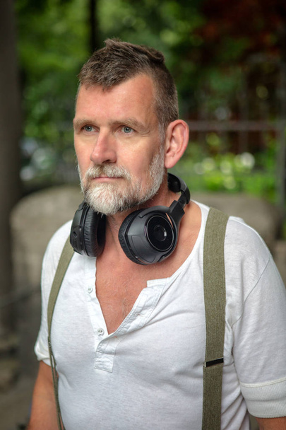 portrait of handsome bearded man in his 50s with headphones  - Foto, afbeelding