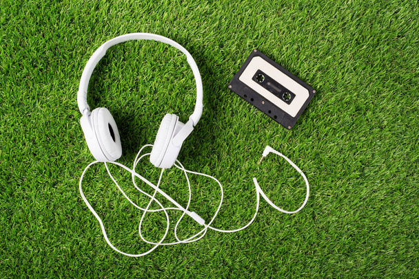 White headphones on a green grass. Top of view - Fotó, kép