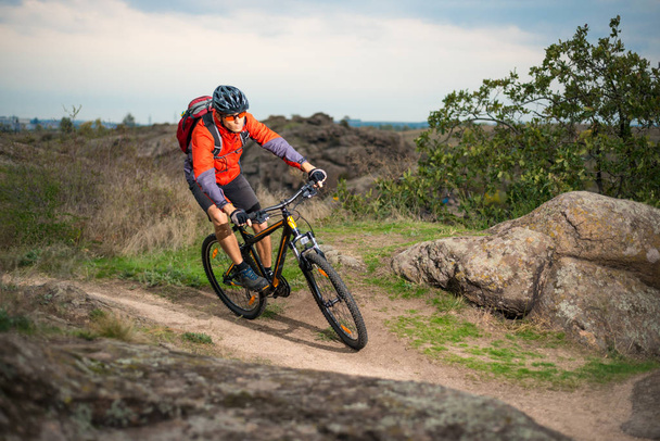 Rowerzysta w kolorze czerwonym, jazda na rowerze na jesienią skalistego szlak. Sport ekstremalny i koncepcja rowery Enduro. - Zdjęcie, obraz