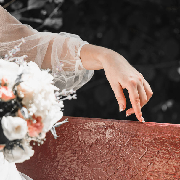 primo piano delle dita della sposa giocano scherzosamente lo sposo. Gli sposi sono seduti su una panchina
 - Foto, immagini