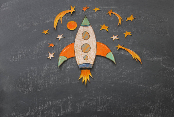 Rocket cut from paper and painted over class room blackboard background. - Foto, Imagem