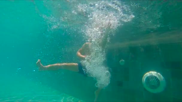 Slowmotion shot z malého chlapce, potápění a koupání v bazénu - Záběry, video
