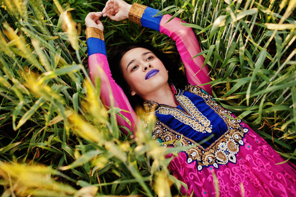 Przetargowej indian dziewczyna w Sari, z fioletowym, warg postawione w polu w zachód słońca. Modny model Indie. - Zdjęcie, obraz