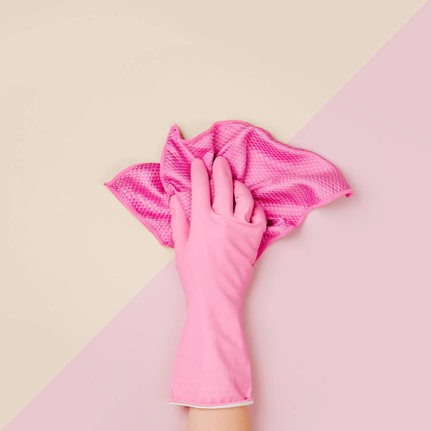 Female hand cleaning on pale pink  background. Cleaning or housekeeping concept background. Copy space.  Flat lay, Top view. - Fotó, kép