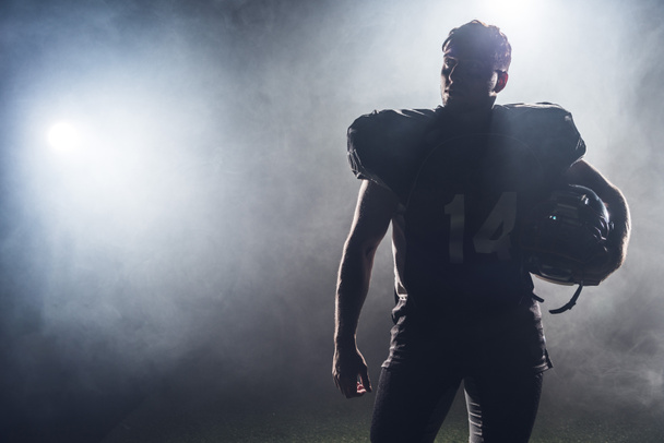 sylwetka zawodnik futbolu amerykańskiego w mundurze przeciwko biały dym - Zdjęcie, obraz