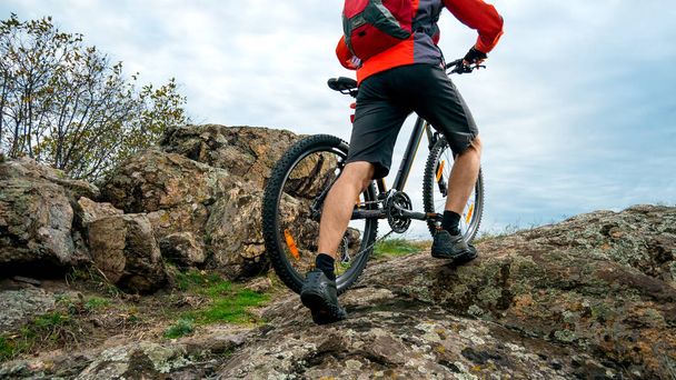 Pyöräilijä Red poimien pyörä ylös syksyllä Rocky Trail. Extreme Sport ja Enduro pyöräily käsite
. - Valokuva, kuva