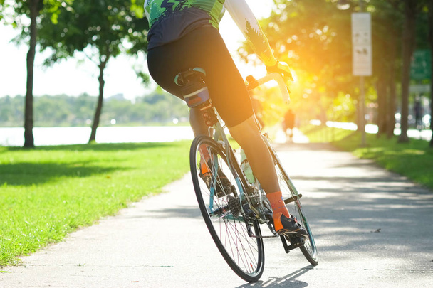 Aja pyörällä tien päällä kaupungin puistossa. Urheilu ja aktiivinen elämä käsite kesäaikaan
 - Valokuva, kuva