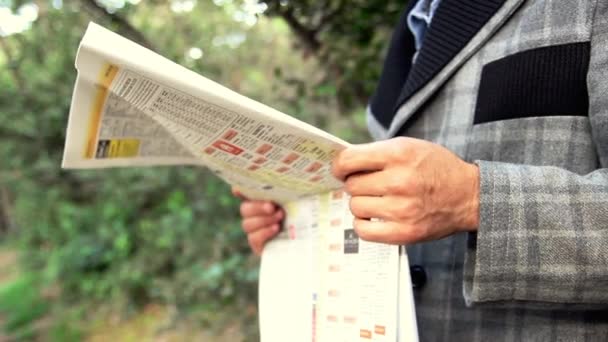 Biznesmen czytanie gazety w ogrodzie - Materiał filmowy, wideo