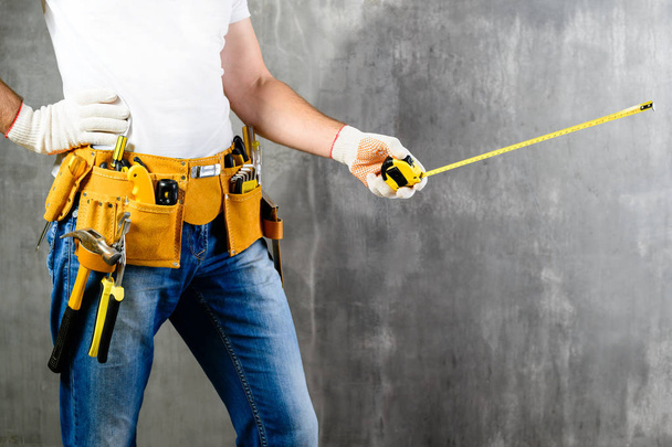 unidentified handyman standing with a tool belt with constructio - Foto, Imagen