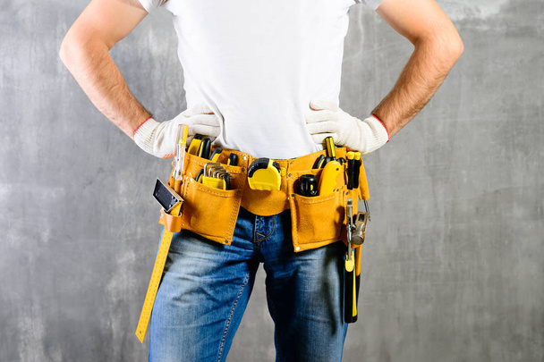 manitas desconocidas con las manos en la cintura y cinturón de herramientas con construcc
 - Foto, Imagen