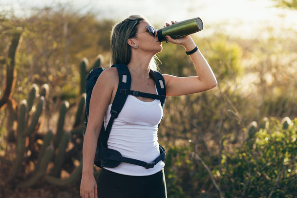Woman taking a break to drink from water bottle while hiking at Brazilian Caatinga - Zdjęcie, obraz