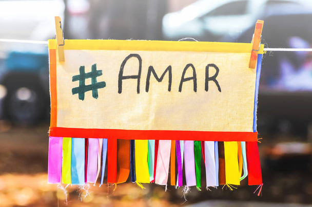 Värikäs lauta, jossa on Brasilian portugaliksi kirjoitettu viesti "rakkaus", joka on ripustettu liittimillä kiinnitetyllä köydellä. Amar viesti, # amar, hashtag amar, kirjoitettu amar portugaliksi
 - Valokuva, kuva