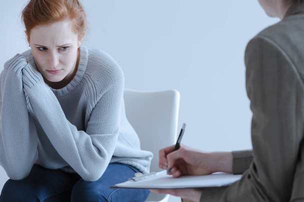 Surullinen nuori nainen, jolla on syömishäiriöitä psykoterapeutin kanssa
 - Valokuva, kuva