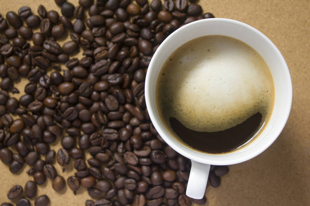 Melkschuim in koffiemokken en koffiebonen - Foto, afbeelding