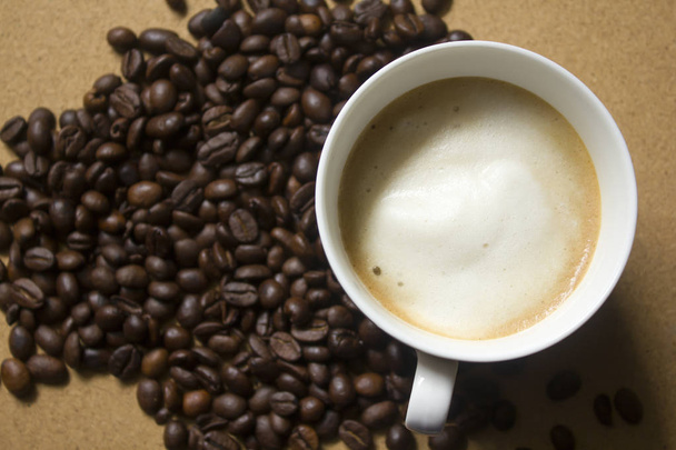 Milk froth in coffee mugs and coffee beans - Фото, зображення