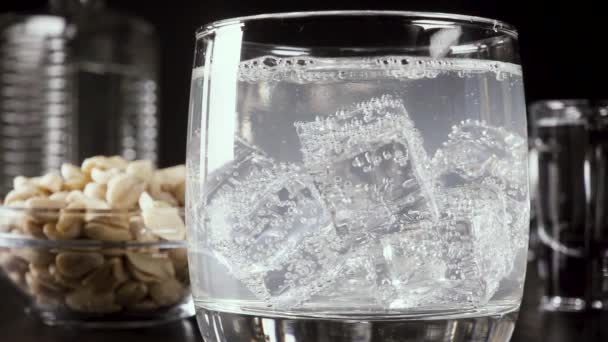 Slow motion a glass of vodka on the table with a snack - Materiał filmowy, wideo