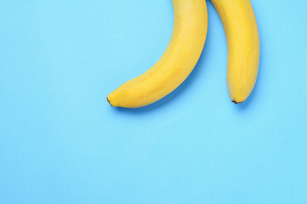 Top view. Bunch of bananas on blue background. Healty concept - Zdjęcie, obraz