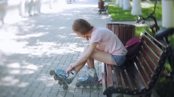 Tekerlekli paten parkta bankta oturan kadın Giydir - Video, Çekim