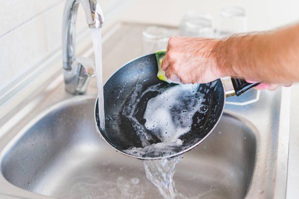 людські руки миють сковороду
 - Фото, зображення