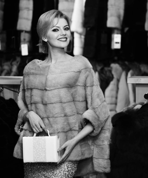Girl with happy face wears furry coat on clothes background - Valokuva, kuva