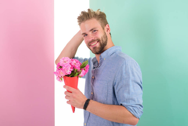 Macho holds bouquet as romantic gift. Guy bring romantic pleasant gift waiting for her. Man ready for date bring pink flowers. Boyfriend happy holds bouquet waiting for date. Best flowers for her - Foto, immagini