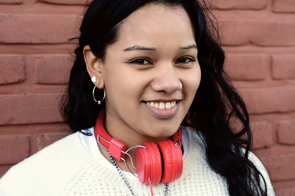 Portrait of young latin woman with headphones listening to music. Enjoying Music. - Фото, изображение