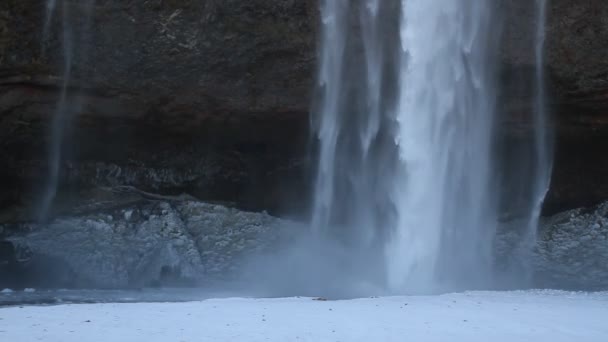 Piękny Seljalandsfoss w Islandii w okresie zimowym. Mrożone piękny wodospad Seljalandsfoss pod światło wschód słońca w zimie, odbicie w rzece. Seljalandsfoss położony jest w regionie południowej Islandii. - Materiał filmowy, wideo