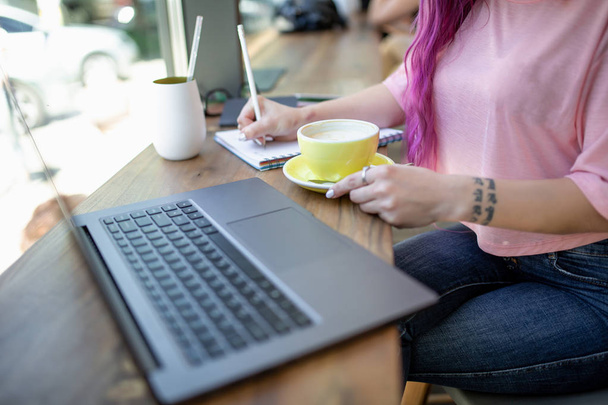 Жінка друкує на ноутбуці з порожнім екраном, сидячи за дерев'яним столом
 - Фото, зображення