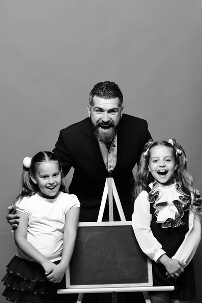Girls and man with happy faces. Bearded teacher and kids - 写真・画像
