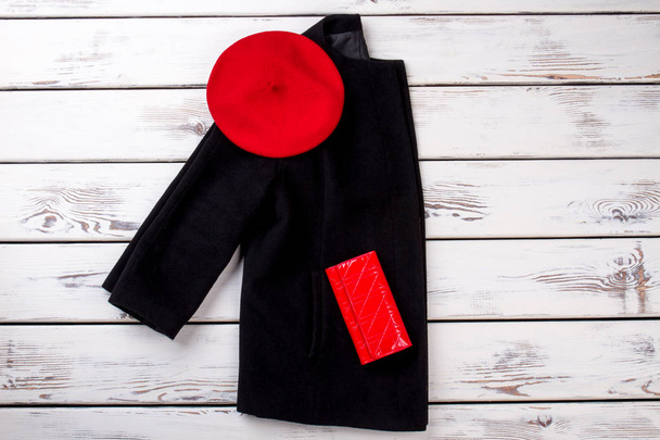 Черная женская куртка в красной шляпе и бумажнике
. - Фото, изображение
