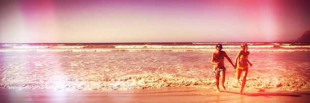 Полная длина пары, бегущей по берегу на пляже в солнечный день
 - Фото, изображение