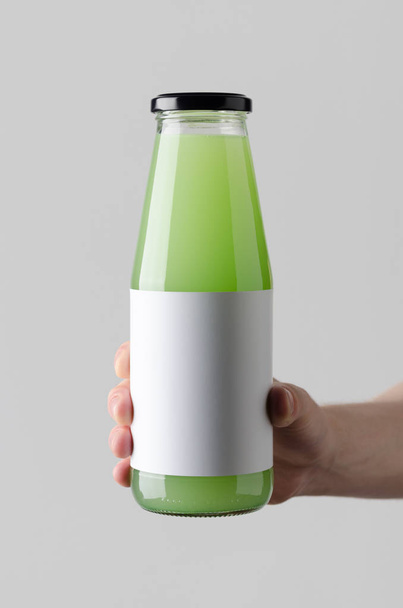 Maquette de bouteille de jus. Étiquette vierge - mains masculines tenant une bouteille de jus sur un fond gris
 - Photo, image