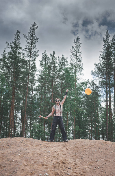 Steampunk style Man in glasses with ax and balloon standing on the hill outdoor - Fotografie, Obrázek