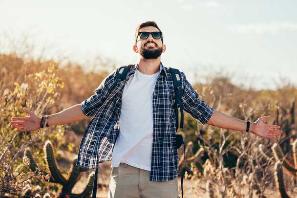 Happy young man hiking with backpack - Photo, image