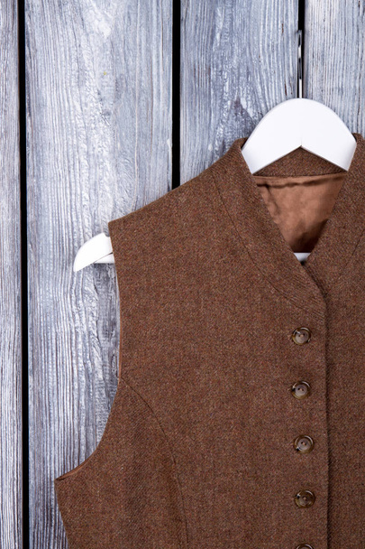 Close-up van bruin mouwloos jasje op hanger. - Foto, afbeelding