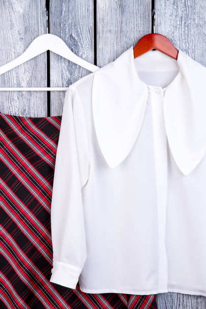 Белая блузка и рубашка на вешалках
. - Фото, изображение