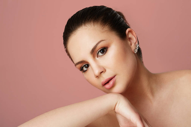 Young girl with big brown eyes and dark eyebrows looking over empty beige colored studio background.Model with light nude make-up.Copy paste text space,close up.Healthcare skin makeup concept. - 写真・画像