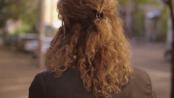 Πίσω όψη του μια γυναίκα με σγουρά μαλλιά τζίντζερ - Πλάνα, βίντεο