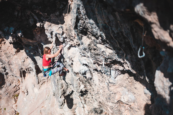 女性は、岩を登っていきます。自然の救済の運動選手列車。トルコでのクライミング。ほっそりした少女は、極端なスポーツに取り組んでいます。アクティブな趣味。登山者は、困難なルートを克服します。. - 写真・画像