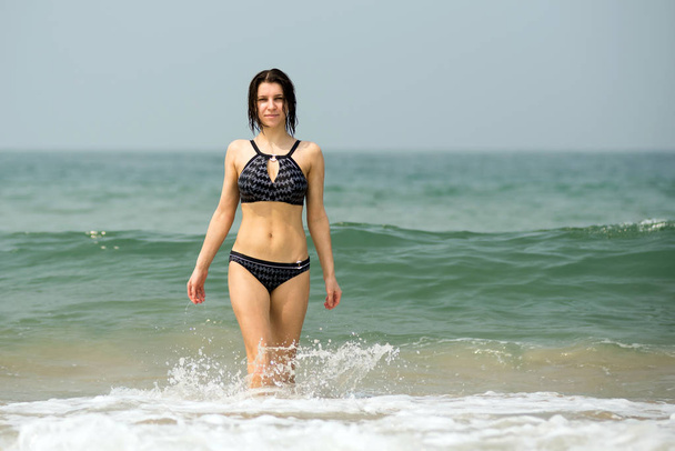 Beautiful young girl coming out of the sea - Foto, Bild