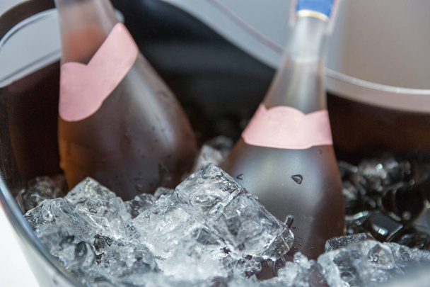 氷のバケツのクローズ アップのバラのスパーク リング ワインのボトル - 写真・画像