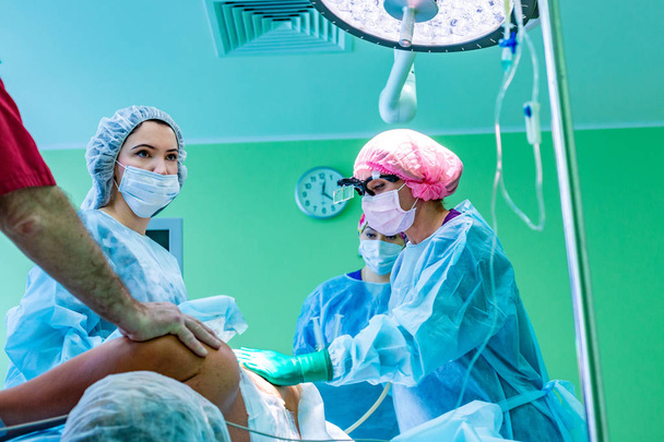operacja liposukcji kosmetycznej w warunkach rzeczywistej sali operacyjnej z grupą chirurgów podczas operacji - Zdjęcie, obraz