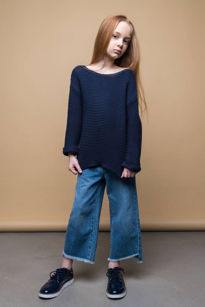 Studio shot of beautiful young redhead girl in jeans and sweater - Fotó, kép