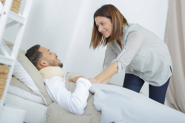 woman caring for sick boyfriend on bed - Фото, зображення