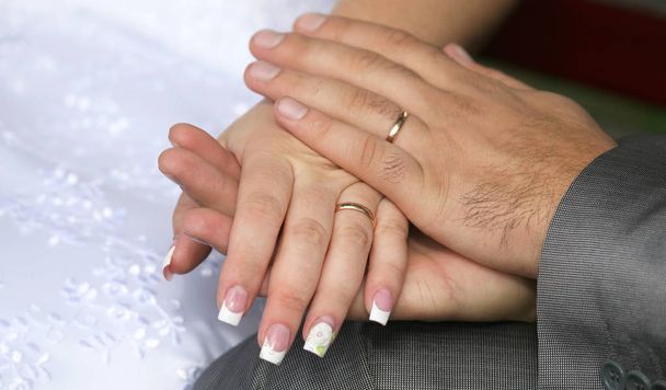 Braut und Bräutigam zeigen ihre Hände mit Eheringen - Foto, Bild